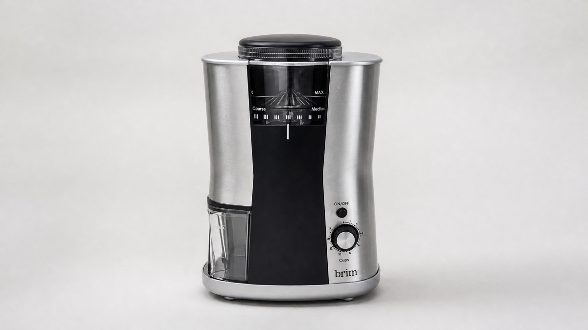Brim conical burr coffee grinder in stainless steel and black on a plain background