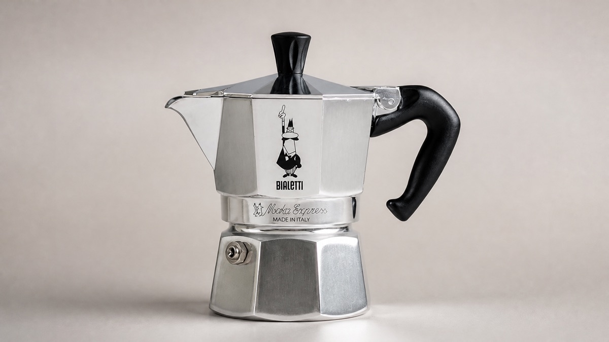 Bialetti Moka Express aluminum stovetop moka pot with black handle on a plain neutral background